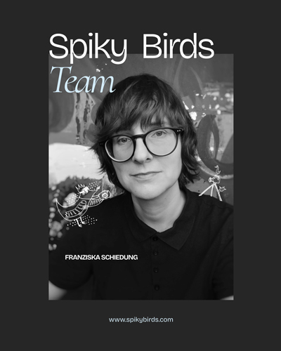 Eine Schwarzweißfotografie zeigt eine Person. Die Person ist weiß, trägt Brille, kinnlanges Haar und ein dunkles Shirt. Auf dem Foto sind kleine Illustrationen: auf der rechten Schulter der Person sitzen zwei kleine Vögel auf einem Stativ, auf der linken Schulter der Person sitzt ein Vogel, der eine Kamera hält. Weiße Schrift auf schwarzem Grund titelt: "Spiky Birds. Team. Franziska Schiedung".